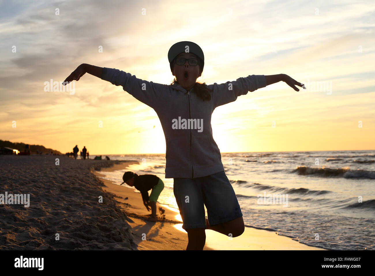 Vacaciones! La niña salta alto en una playa de arena Foto de stock
