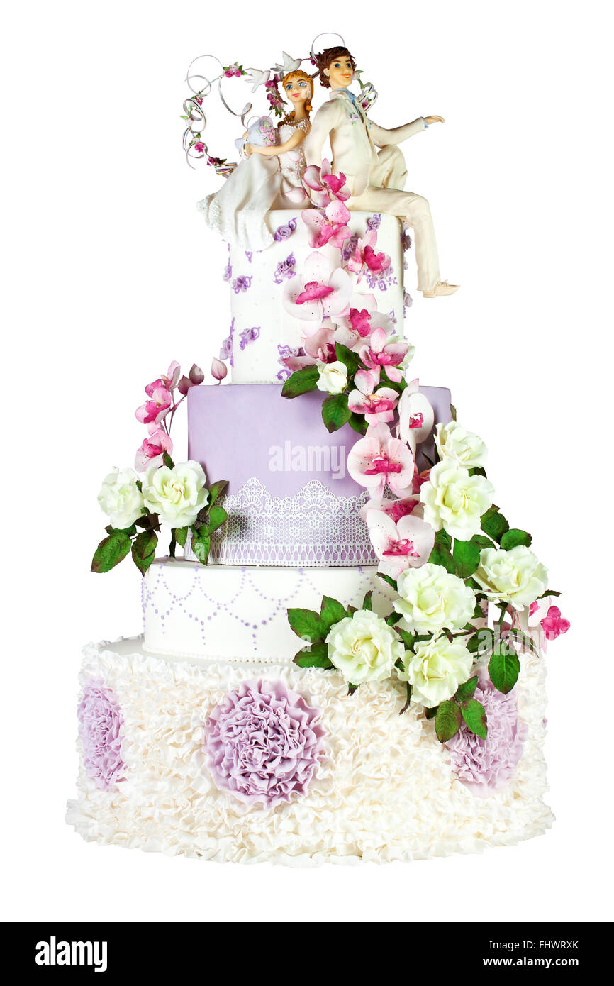 Pastel de bodas blanco y morado decorada con rosas blancas y orquídeas púrpura con una pareja a la novia y el novio en la parte superior. En aislados Foto de stock