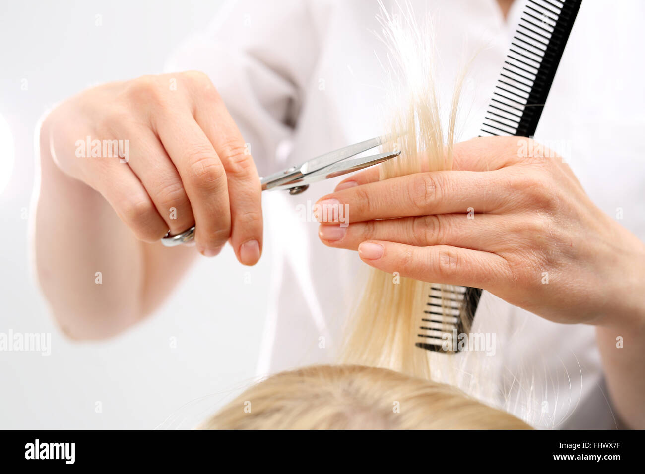Corte de pelo de peluquería mujer en una peluquería. La subcotización finaliza la división del cabello Foto de stock