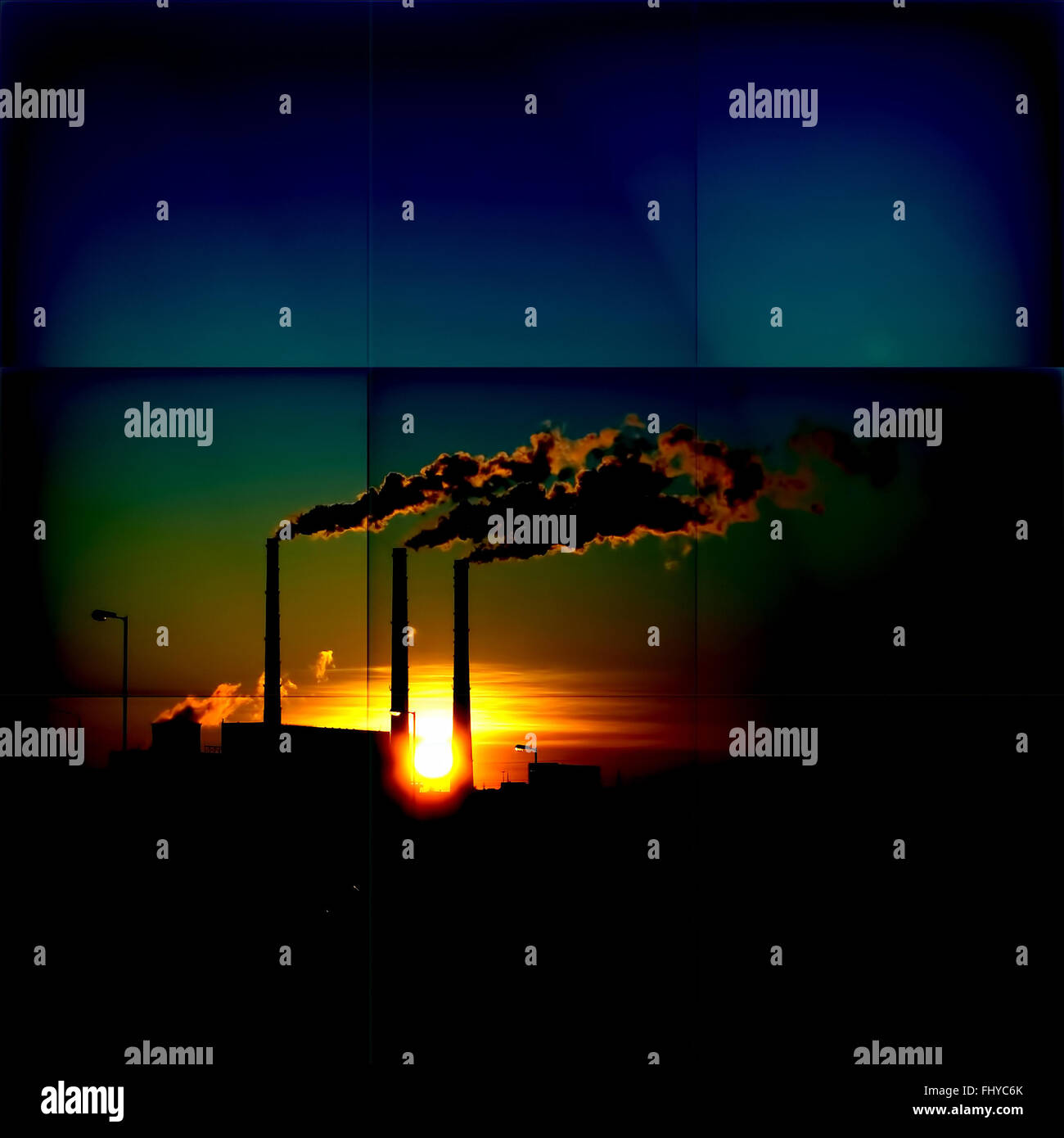 Puesta de sol sobre un fondo de chimeneas de fumar Foto de stock