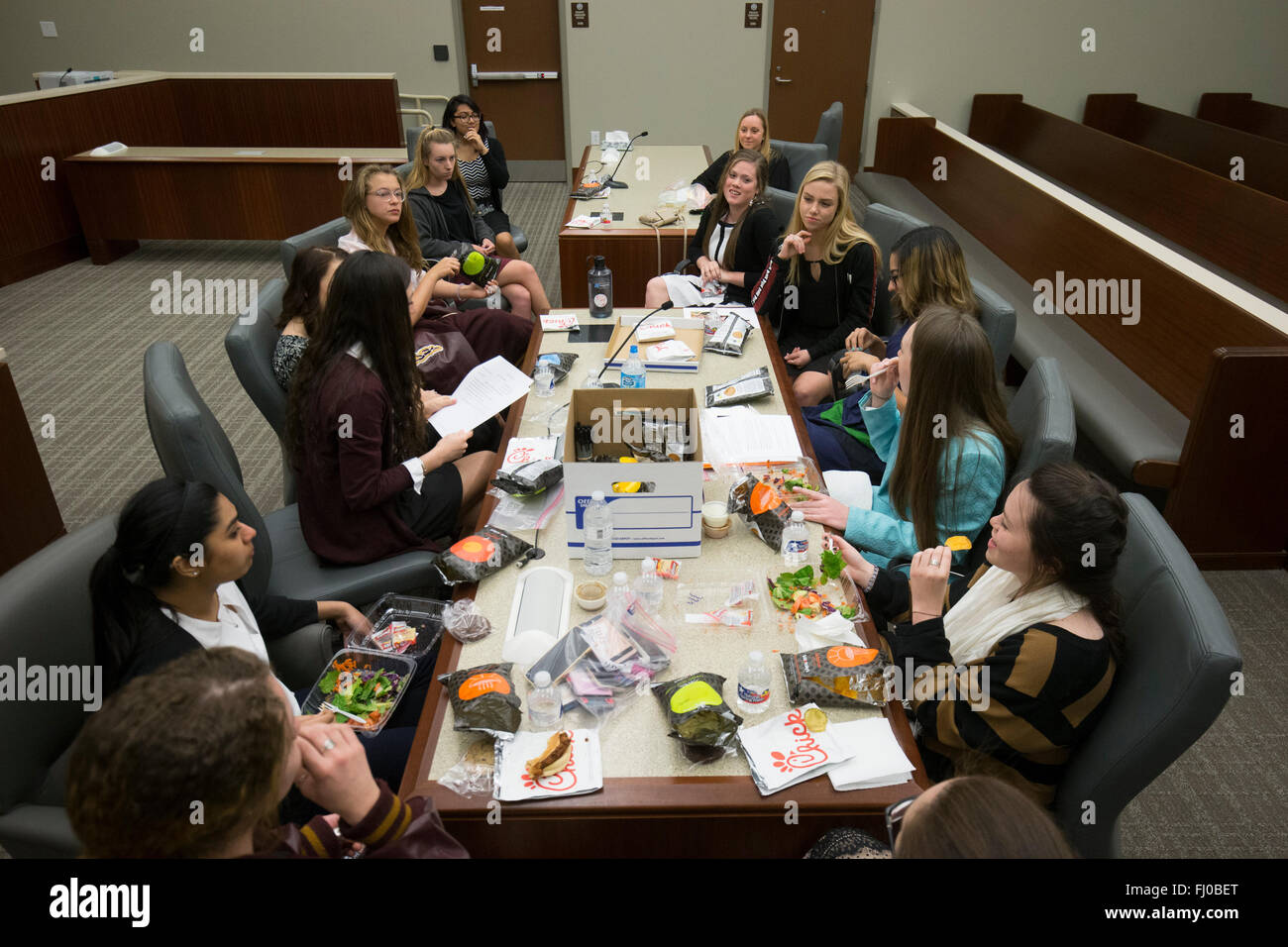 Las chicas adolescentes que sirven en el equipo de la defensa durante el juicio ficticio almorzar durante los debates en la sala de la Corte en San Marcos, Texas Foto de stock