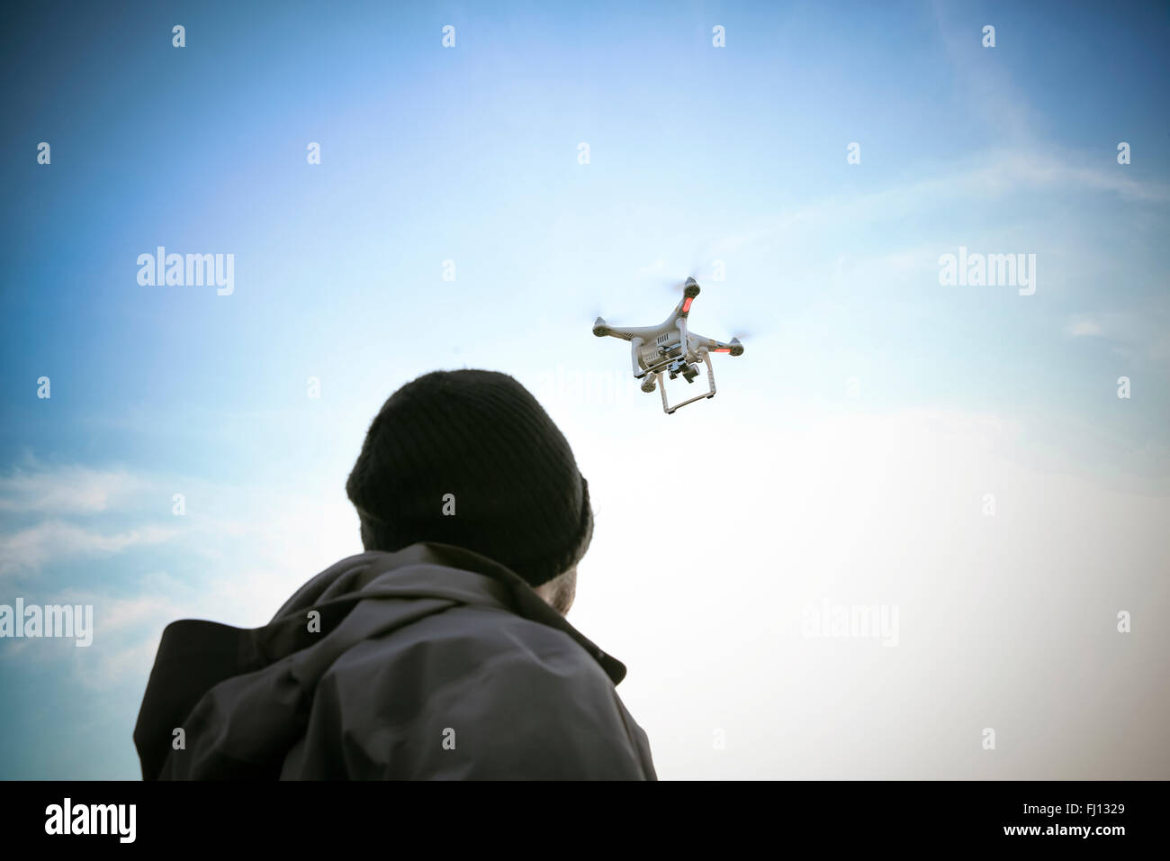 Vista posterior del hombre volando drone Foto de stock