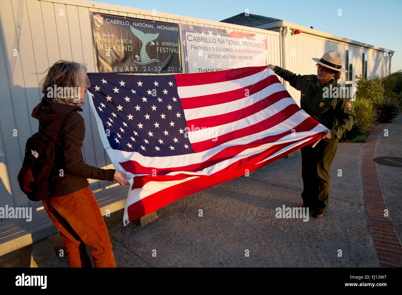 Guardaparques visitante y plegado de la bandera, el Monumento Nacional Cabrillo, en San Diego, California, EE.UU. Foto de stock