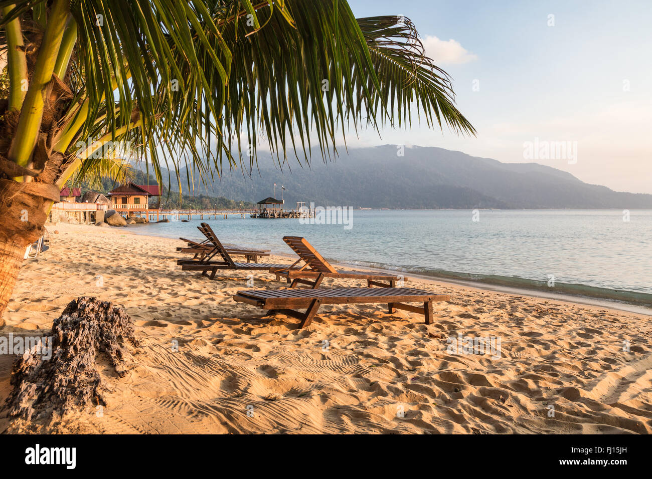 Sillas sobre una larga playa en Pulau Tioman, Malasia Foto de stock