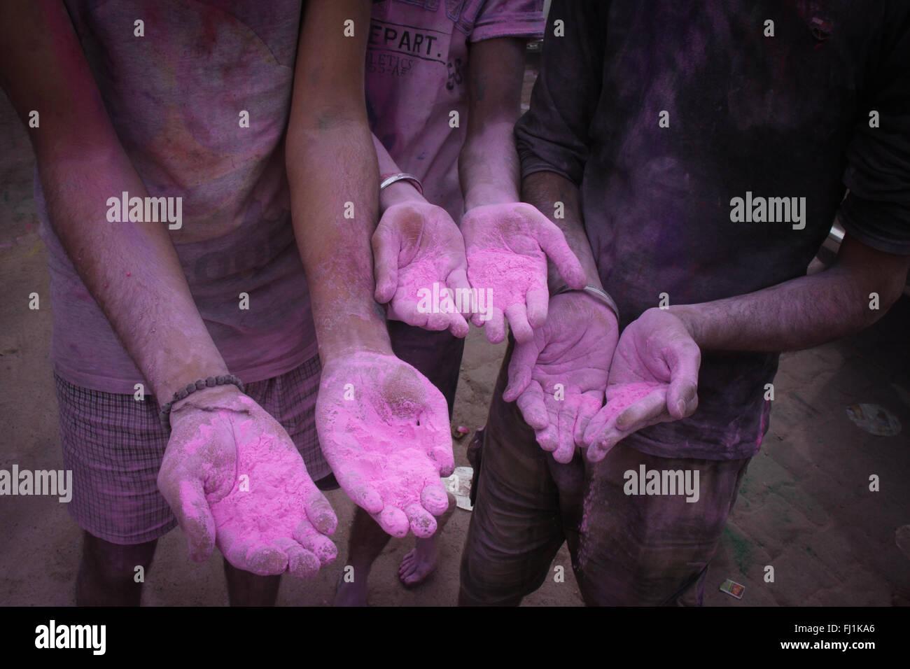 Manos cubiertas con Holi color rosa durante el festival de Holi en Vrindavan, India Foto de stock