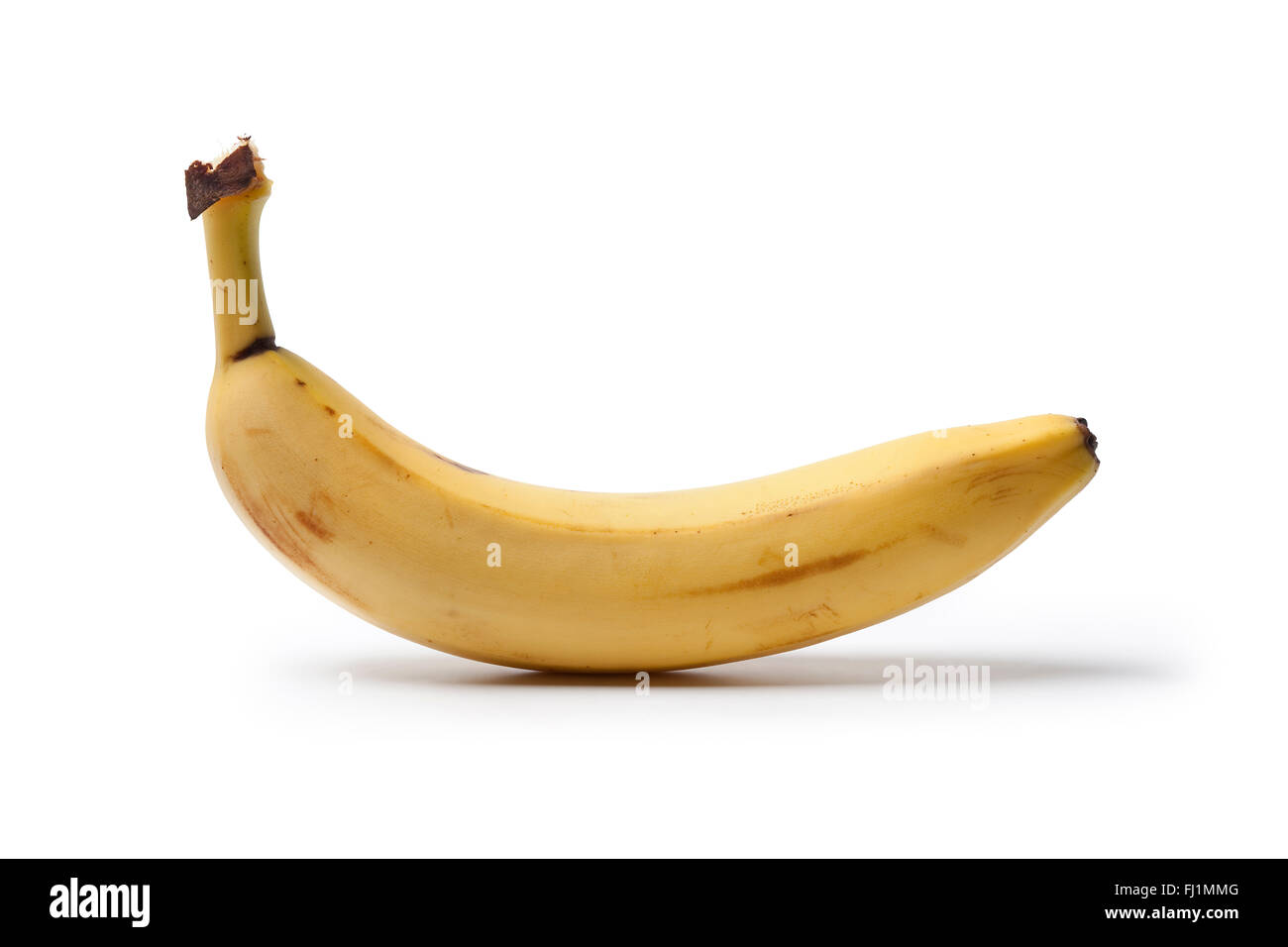 Todo un plátano sin pelar sobre fondo blanco. Foto de stock