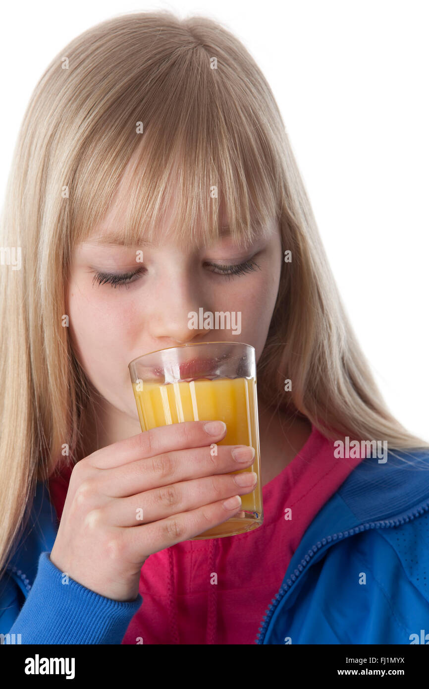 Adolescente beber un vaso de jugo de naranja en el fondo blanco. Foto de stock
