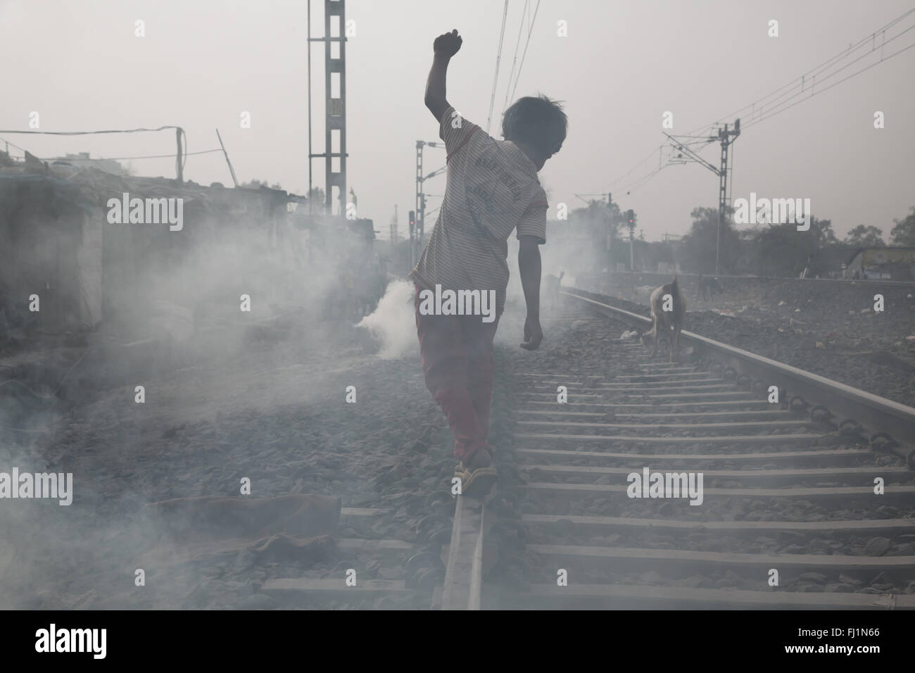 El niño está caminando por los rieles del tren en Bhopal, India Foto de stock