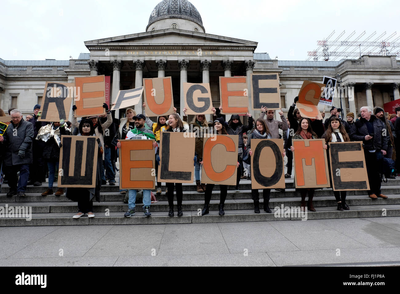 Los manifestantes sosteniendo pancarta leyendo 'bienvenida' refugiados Foto de stock