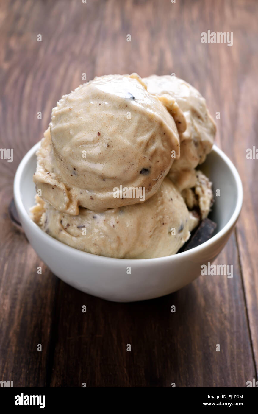 Bolas de helados caseros en el recipiente sobre la mesa de madera Foto de stock