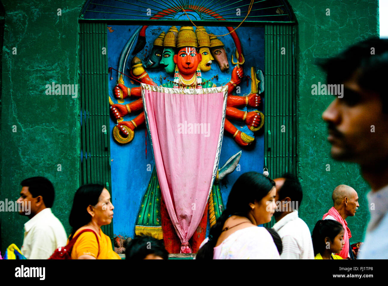La gente pasando por delante del templo de Hanuman, Varanasi, India Foto de stock