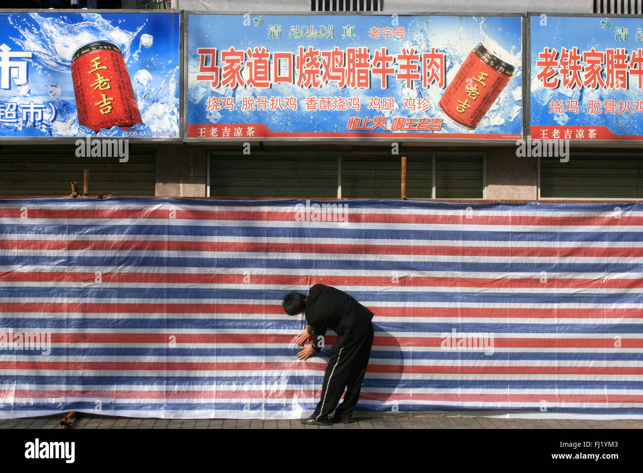 Los hombres en el trabajo en una calle de Shanghai, China Foto de stock