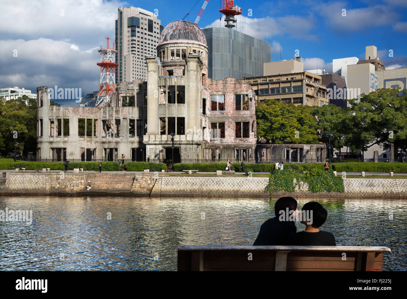 Haz el amor y no la guerra. Una pareja se sienta en frente de la cúpula de la bomba de Hiroshima, Japón Foto de stock