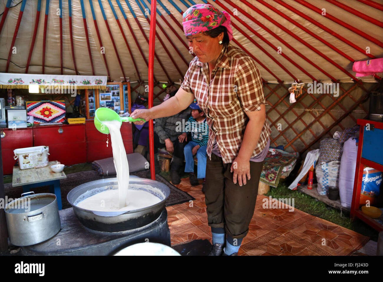 Una mujer nómada está hirviendo y preparar kumis leche caballos tradicional en una yurta tradicional ger en Mongolia Foto de stock