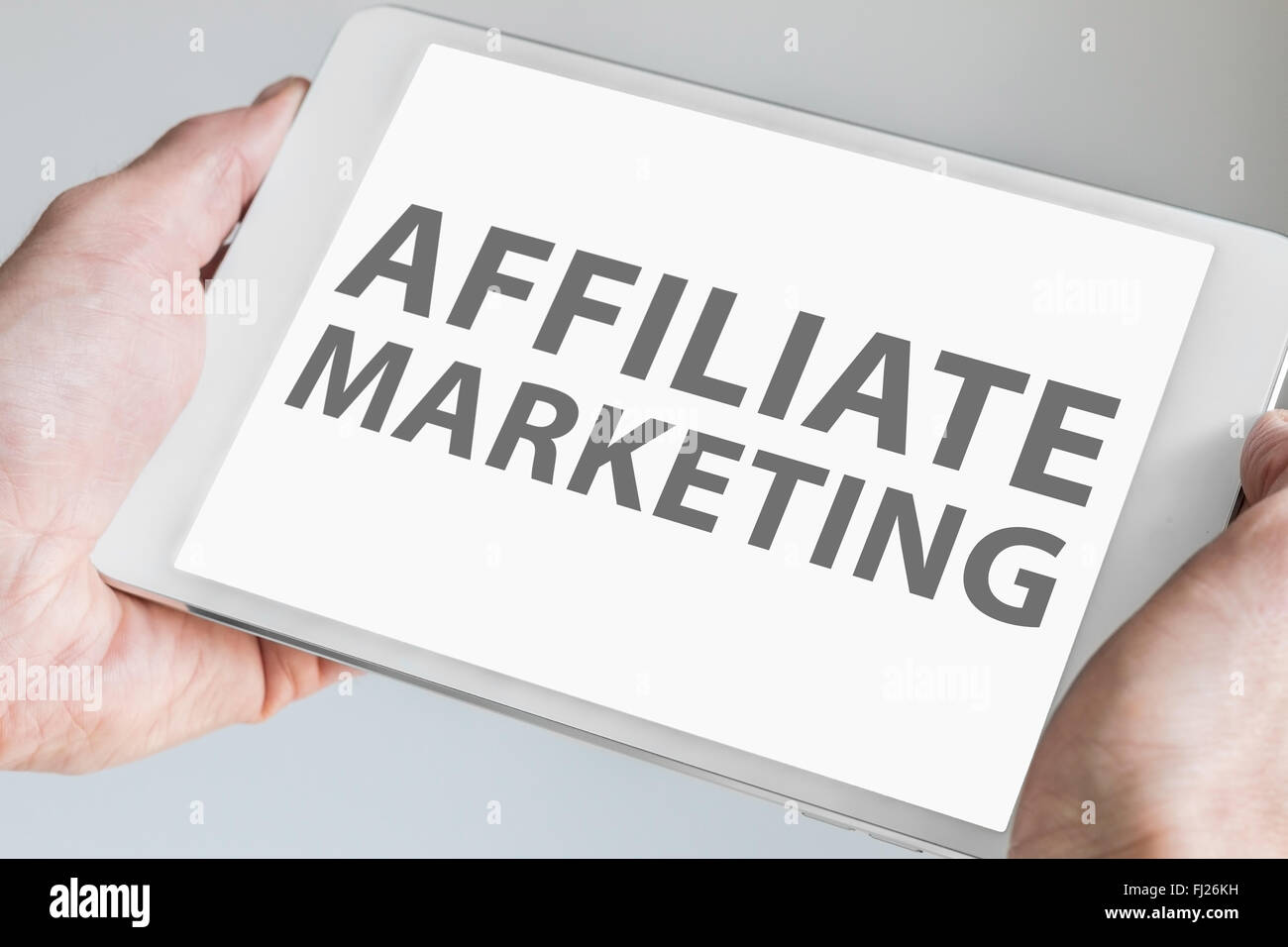 Affiliate Marketing el texto que aparece en la pantalla táctil de Tablet moderno o dispositivo inteligente. Concepto de marketing online web. Foto de stock
