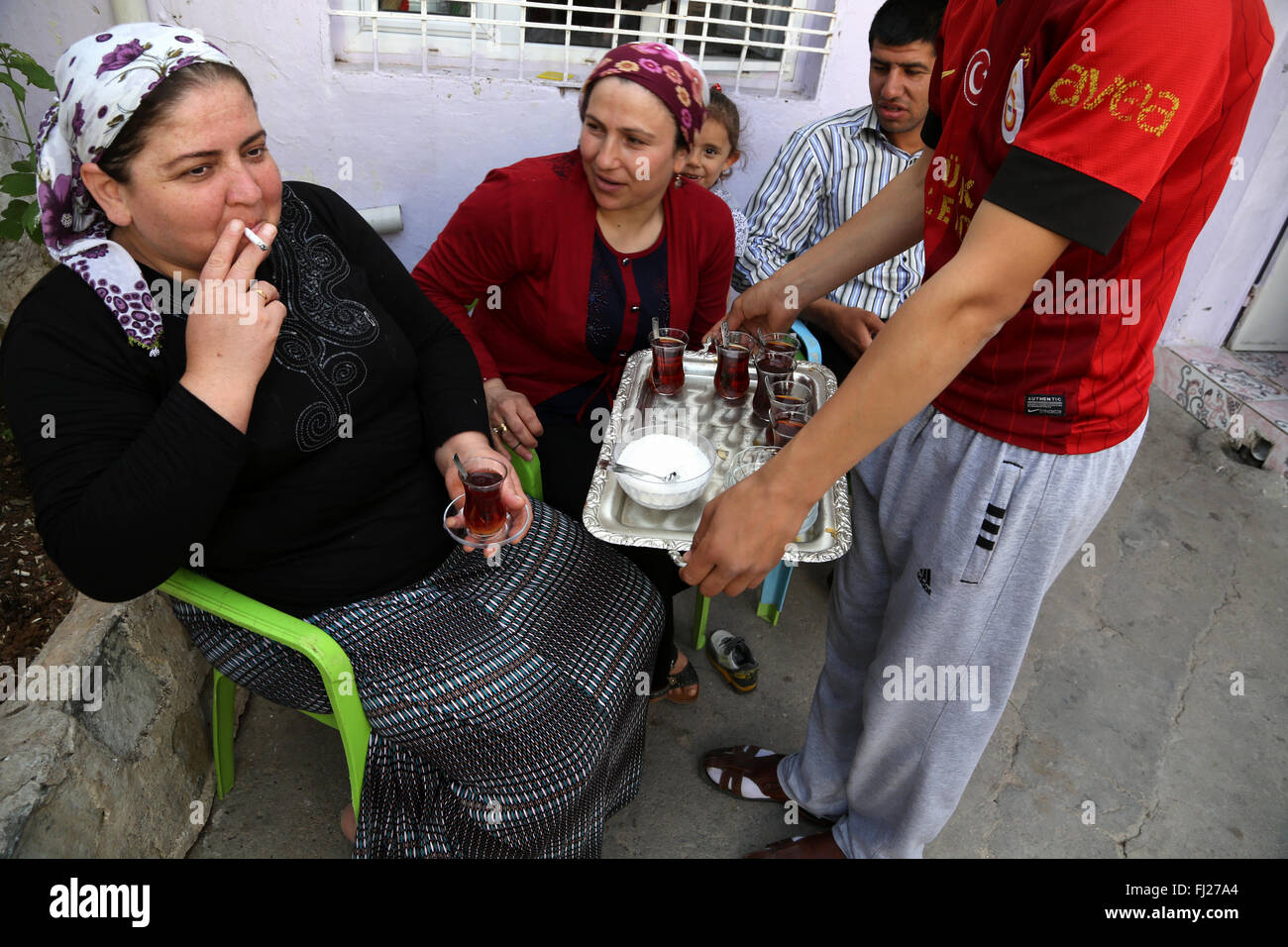 Mujer kurda beber té y fumar en su casa en Mardin, Turquía Foto de stock