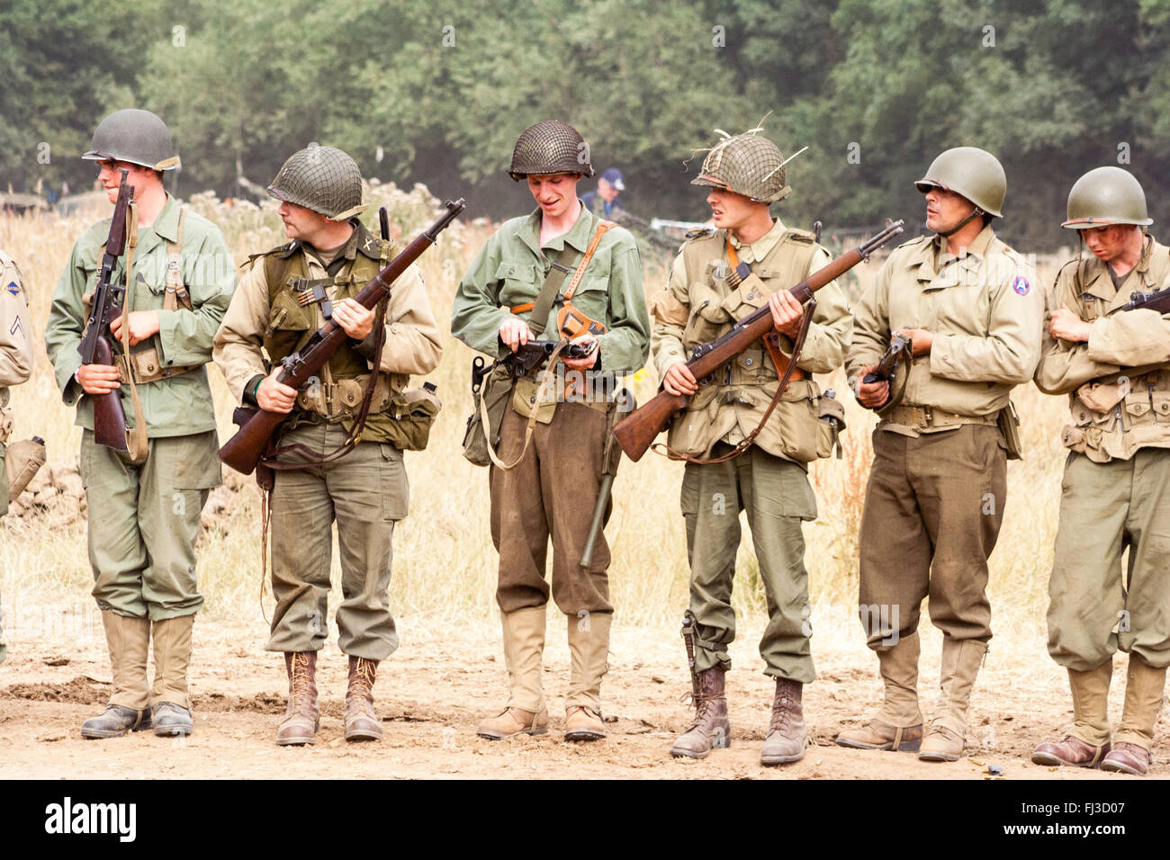 La segunda guerra re la promulgación. Línea de seis americanos, todos en diferentes o variaciones de uniformes de pie con rifles en la lista Fotografía de stock - Alamy