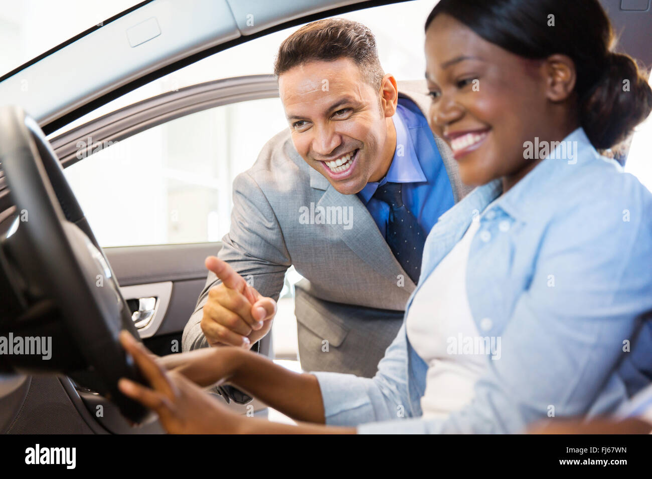 Hermosa Afroamericana comprar un coche en el concesionario Foto de stock