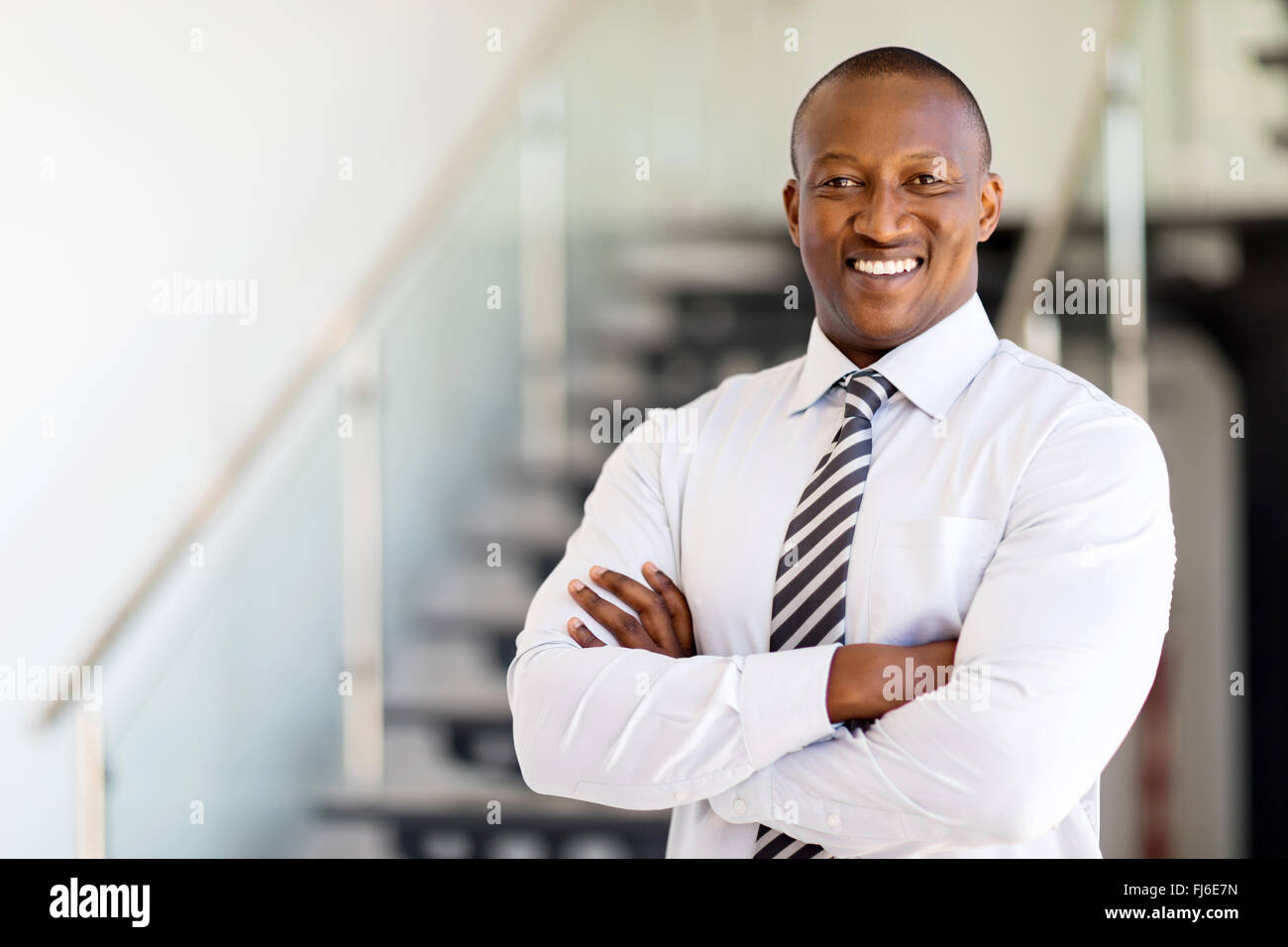 El empleado de la oficina de África con éxito con los brazos cruzados Foto de stock