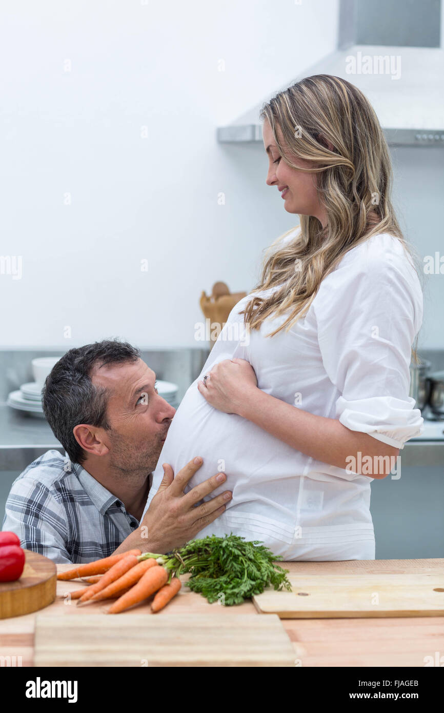 El hombre besando el vientre de la mujer embarazada Foto de stock