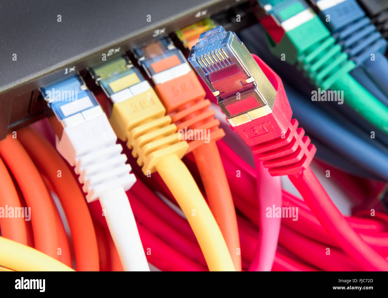 Coloridos cables de red conectados a un conmutador Foto de stock
