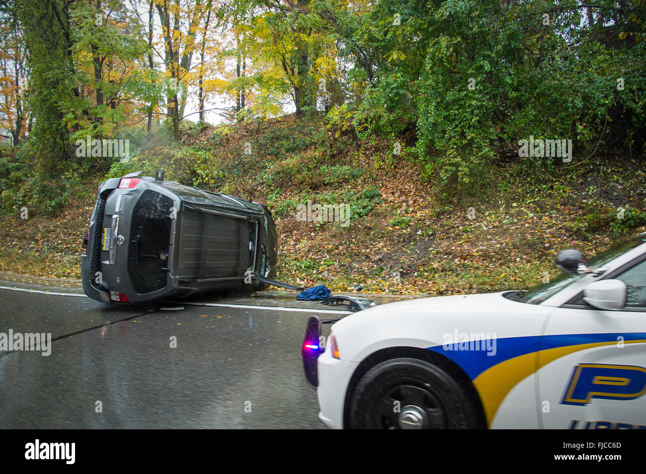 Volcado el automóvil con el coche de la policía en la escena de un accidente, Filadelfia, EE.UU. Foto de stock