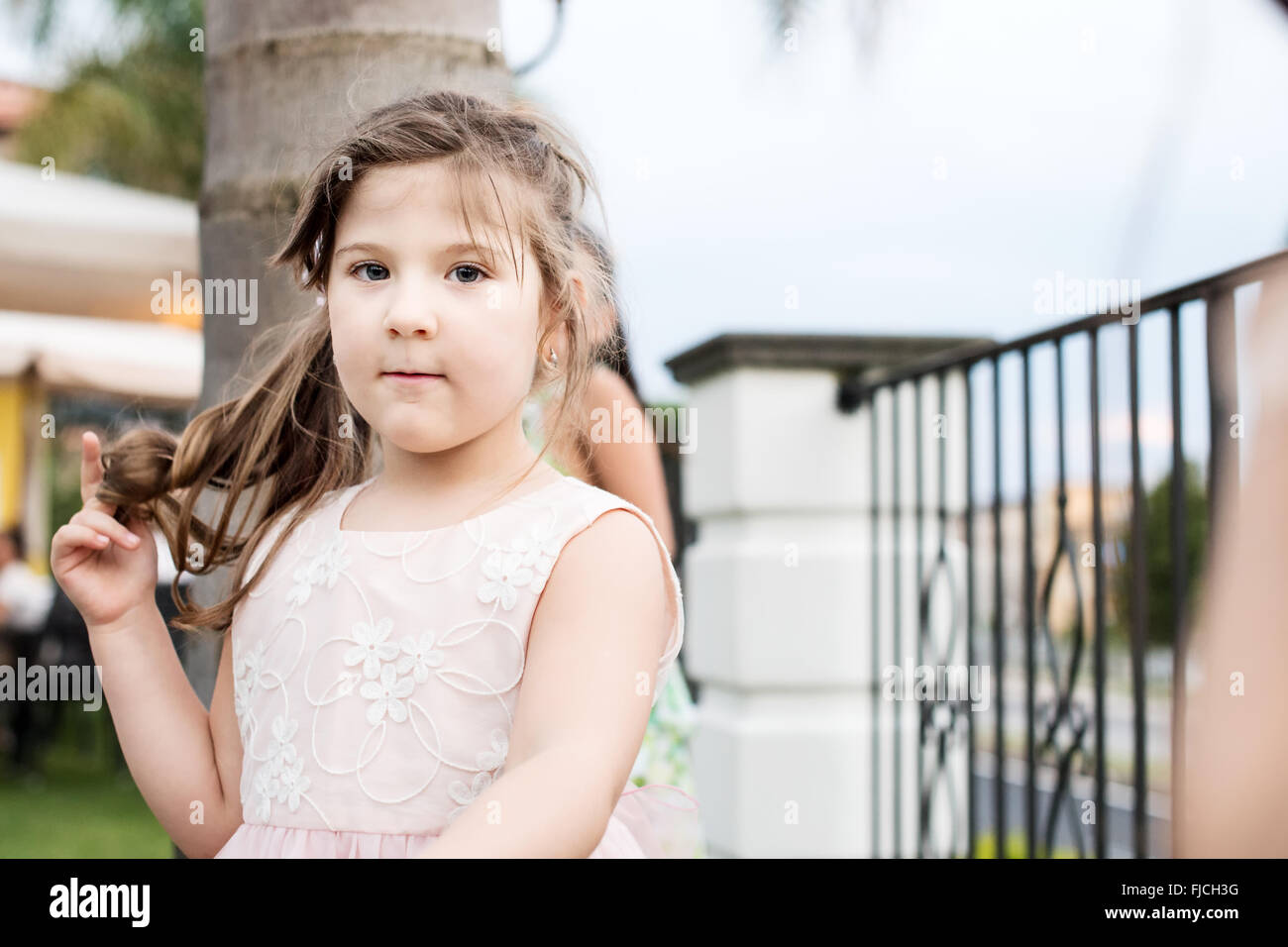 Retrato de niña con ojos azules tocando su cabello Foto de stock