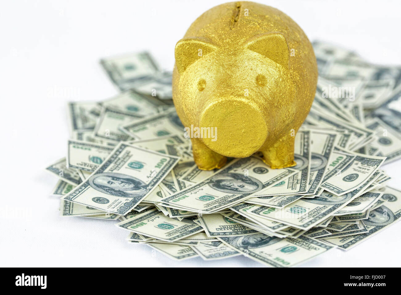 Golden Piggy banco en pila de billetes de 100 dólares. Concepto de riqueza, prosperidad y éxito. Foto de stock