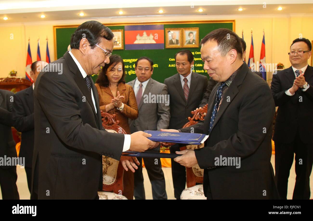 (160302) -- PHNOM PENH, Marzo 2, 2016 (Xinhua) -- El ministro Camboyano de Correos y Telecomunicaciones Prak Sokhonn (L) intercambios de documentos con Huang Xinglong, presidente de la red de comunicaciones de fibra óptica de Camboya (CFOCN), durante una ceremonia de firma en Phnom Penh, Camboya, 2 de marzo de 2016. Camboya el miércoles concedió un contrato en condiciones favorables para la red de comunicaciones de fibra óptica de Camboya (CFOCN), una filial del grupo HyalRoute basada en Shenzhen, invertirá 69,7 millones de dólares EE.UU. en la construcción y el funcionamiento de los cables submarinos y una estación de aterrizaje en el sudoeste de la provincia de Preah Sihanouk. Foto de stock
