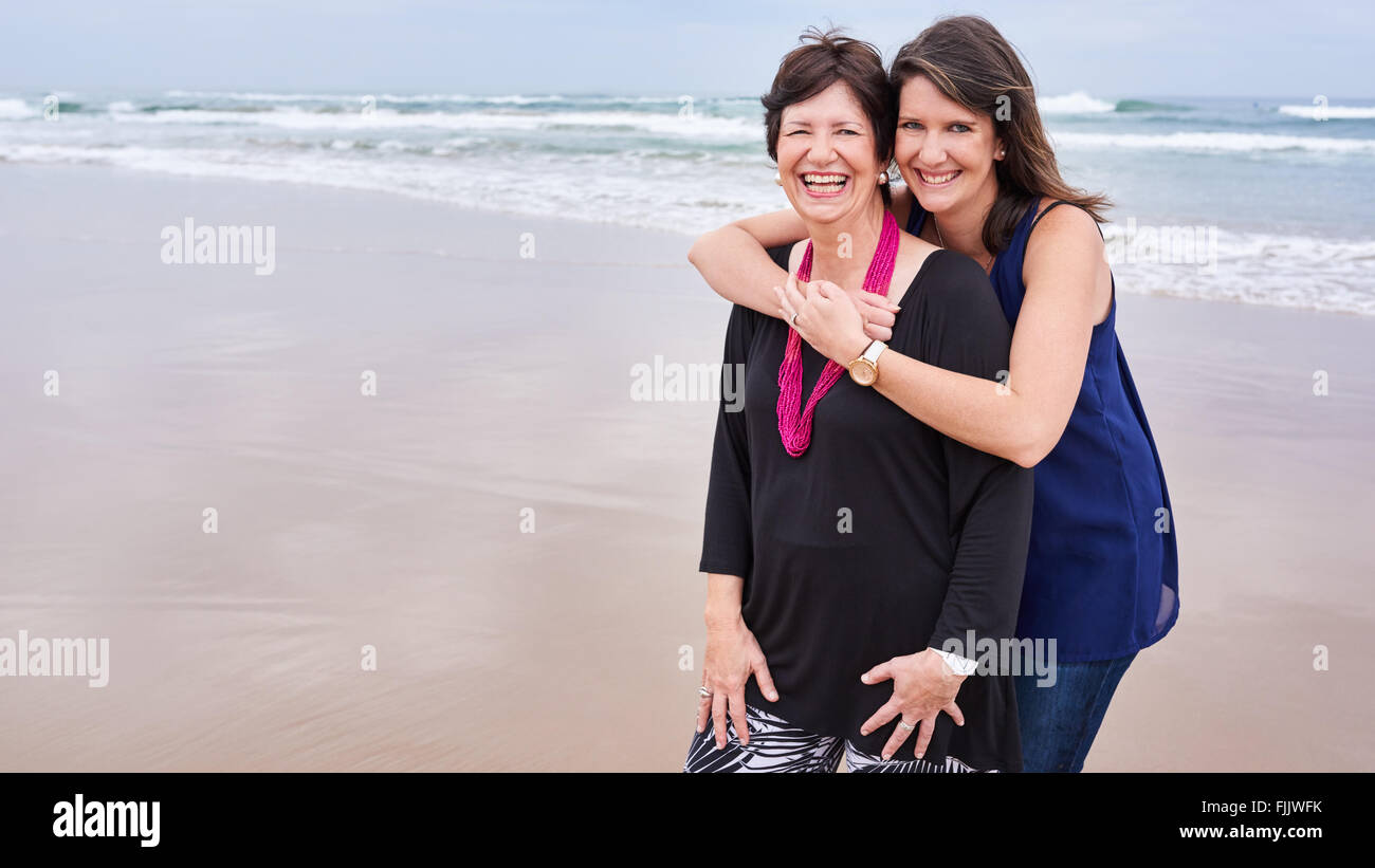 Madre e hija juntas en la playa con espacio de copia Foto de stock