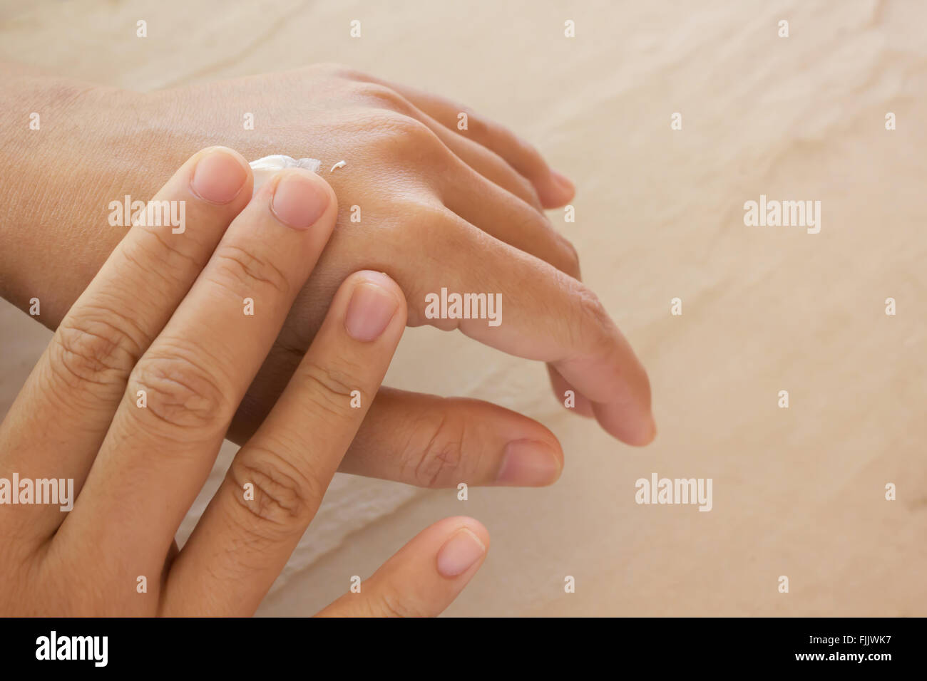 Las mujeres las manos secas, aplicar loción para el cuidado de la piel o con espacio de copia Foto de stock