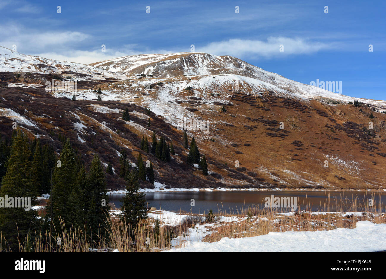 Lago de las montañas cubiertas de nieve en un día soleado Foto de stock