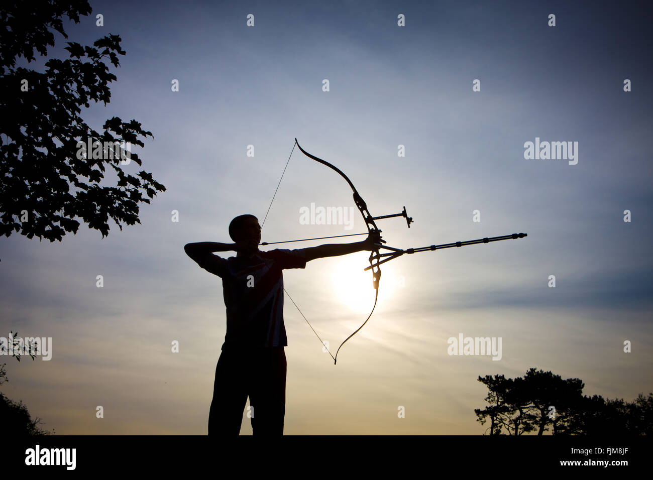 Imagen icónica de un arquero disparando una flecha con un arco, Foto de stock