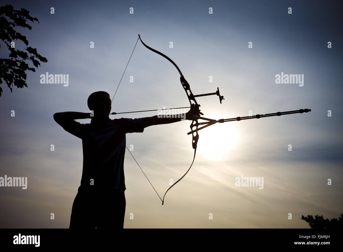 Imagen icónica de un arquero disparando una flecha con un arco, Foto de stock