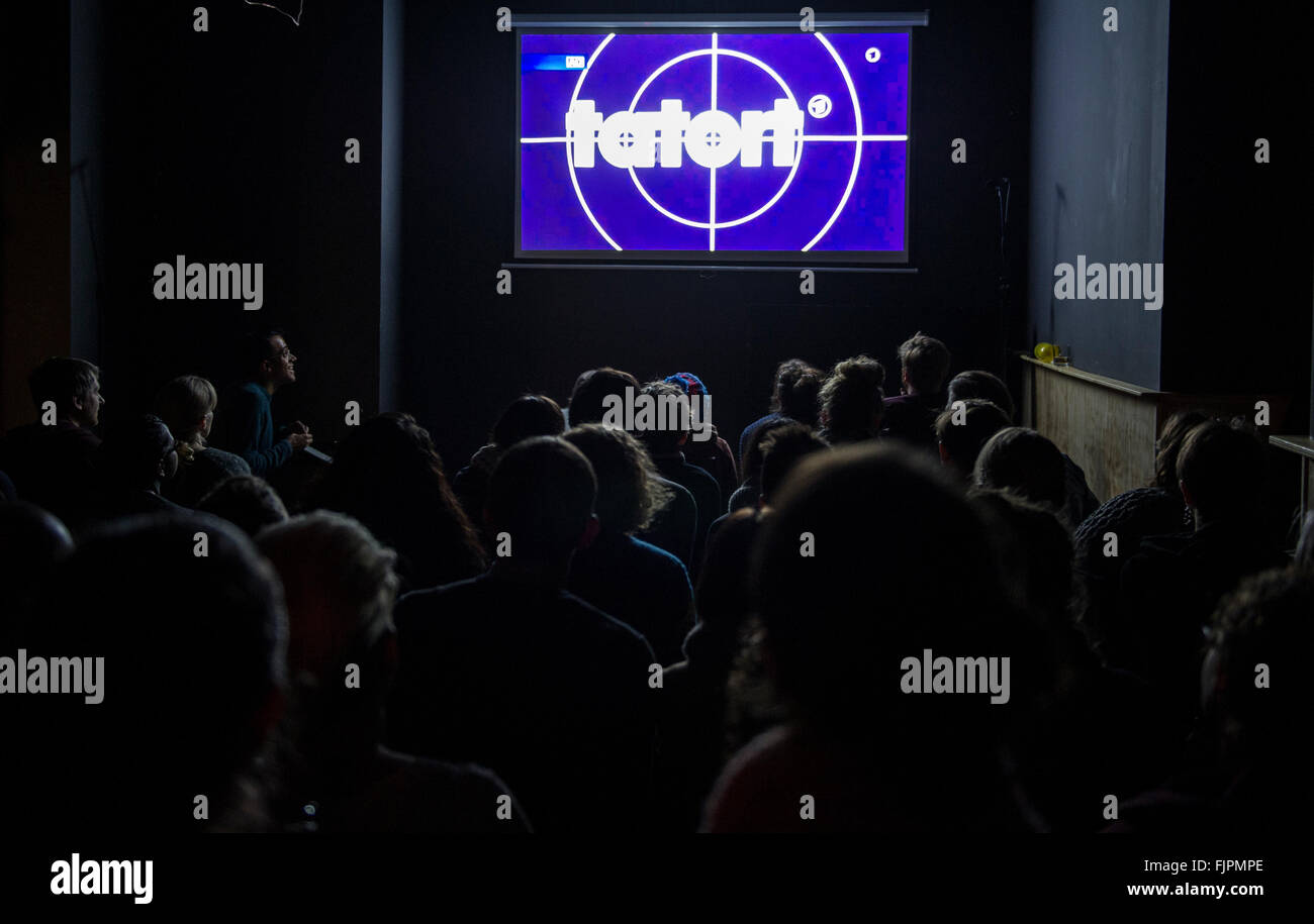 Berlín, Alemania. 28 Feb, 2016. El logotipo del espectáculo 'Tatort' puede ser visto en una pantalla en la "Comedia Café Berlín" en Berlín, Alemania, el 28 de febrero de 2016. Viendo 'Tatort' es ya una tendencia en muchos pubs, pero "Tatort" en inglés es algo diferente en el barrio de Berlin Neukoelln. Durante el screening cómicos improvisar una traducción de la transmisión en vivo de la detective show. Foto: Paul ZINKEN/dpa/Alamy Live News Foto de stock