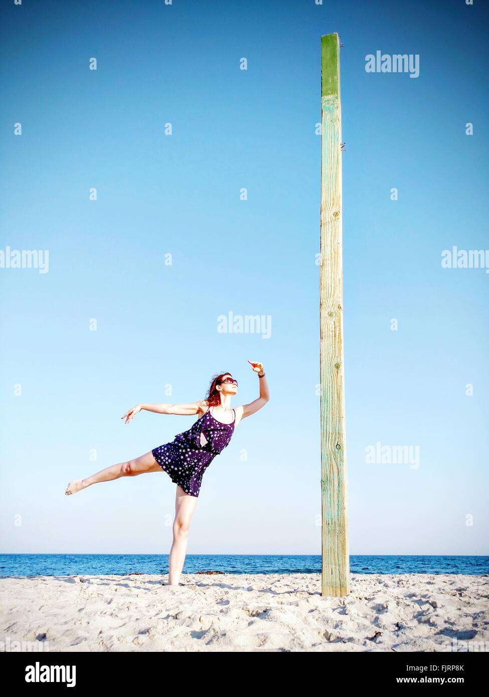 Mujer Bailando en la playa contra el cielo claro Foto de stock