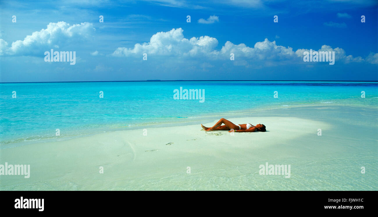 Foto Panorámica de la mujer descansando en la arena durante sus vacaciones en el paraíso de la isla favorita Foto de stock