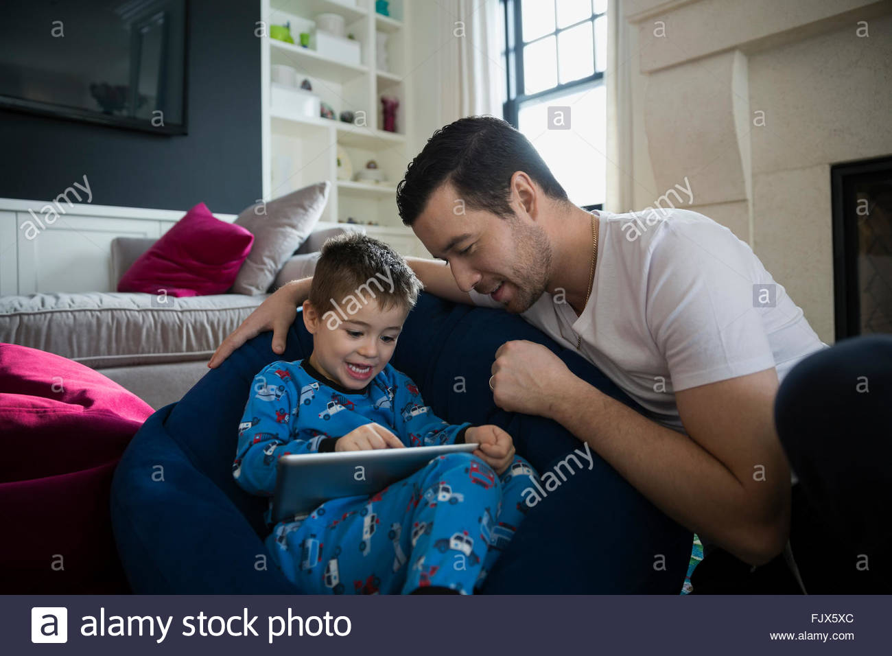 Padre e hijo en pijama mediante tableta digital Foto de stock