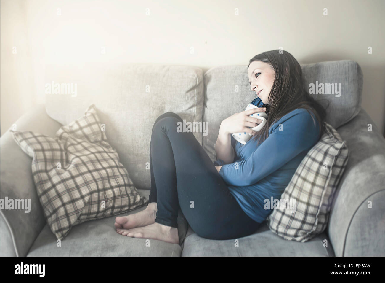 Mujer joven descansando en el sofá-cama Foto de stock