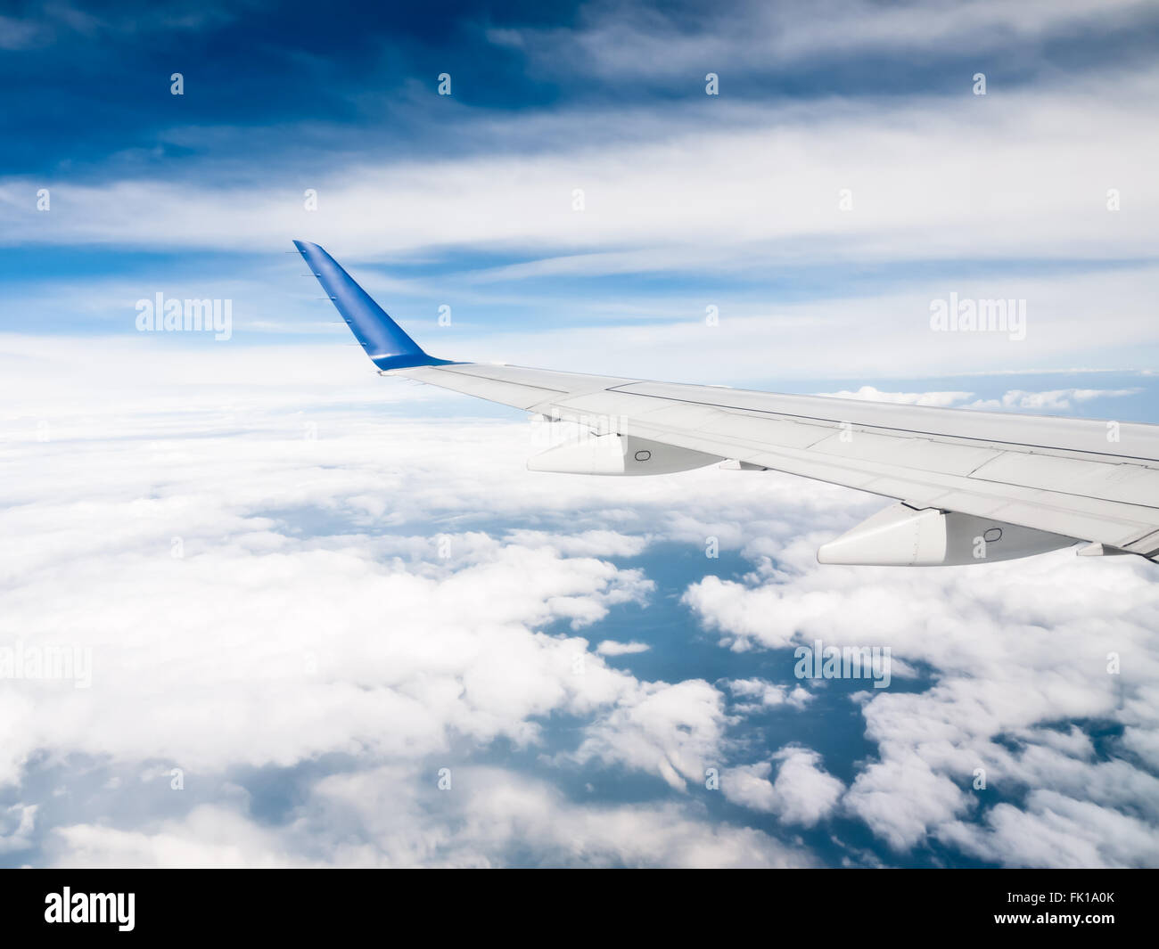 Ala de avión por encima de las nubes con un cielo azul Foto de stock