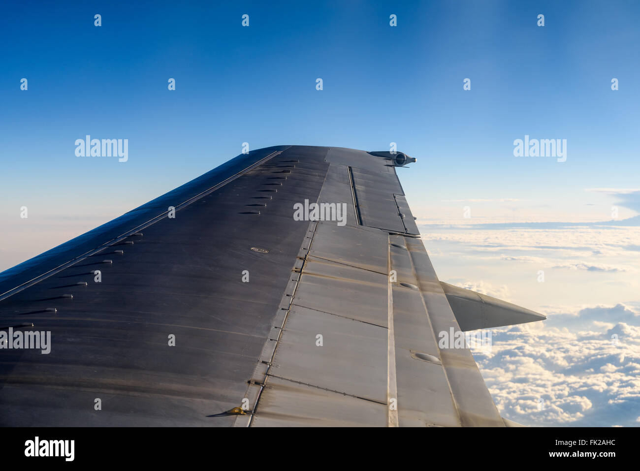 La vista de la ventana de ala de avión volar por encima de las nubes Foto de stock
