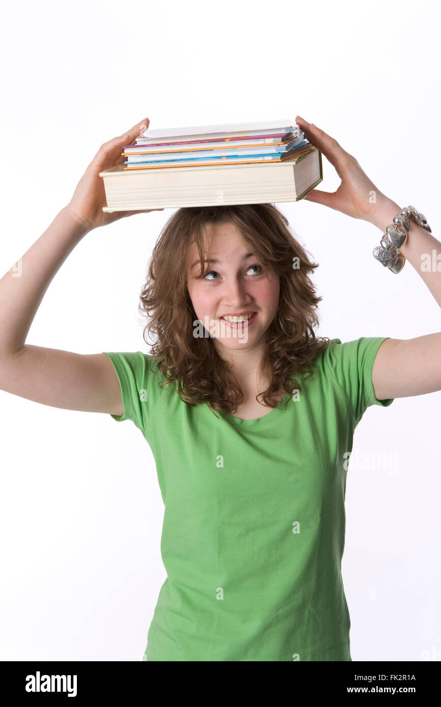 Adolescente es llevar libros sobre su cabeza sobre fondo blanco. Foto de stock