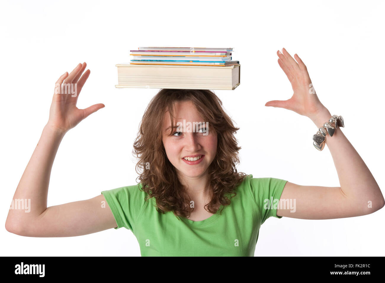 Adolescente es llevar libros sobre su cabeza sobre fondo blanco. Foto de stock