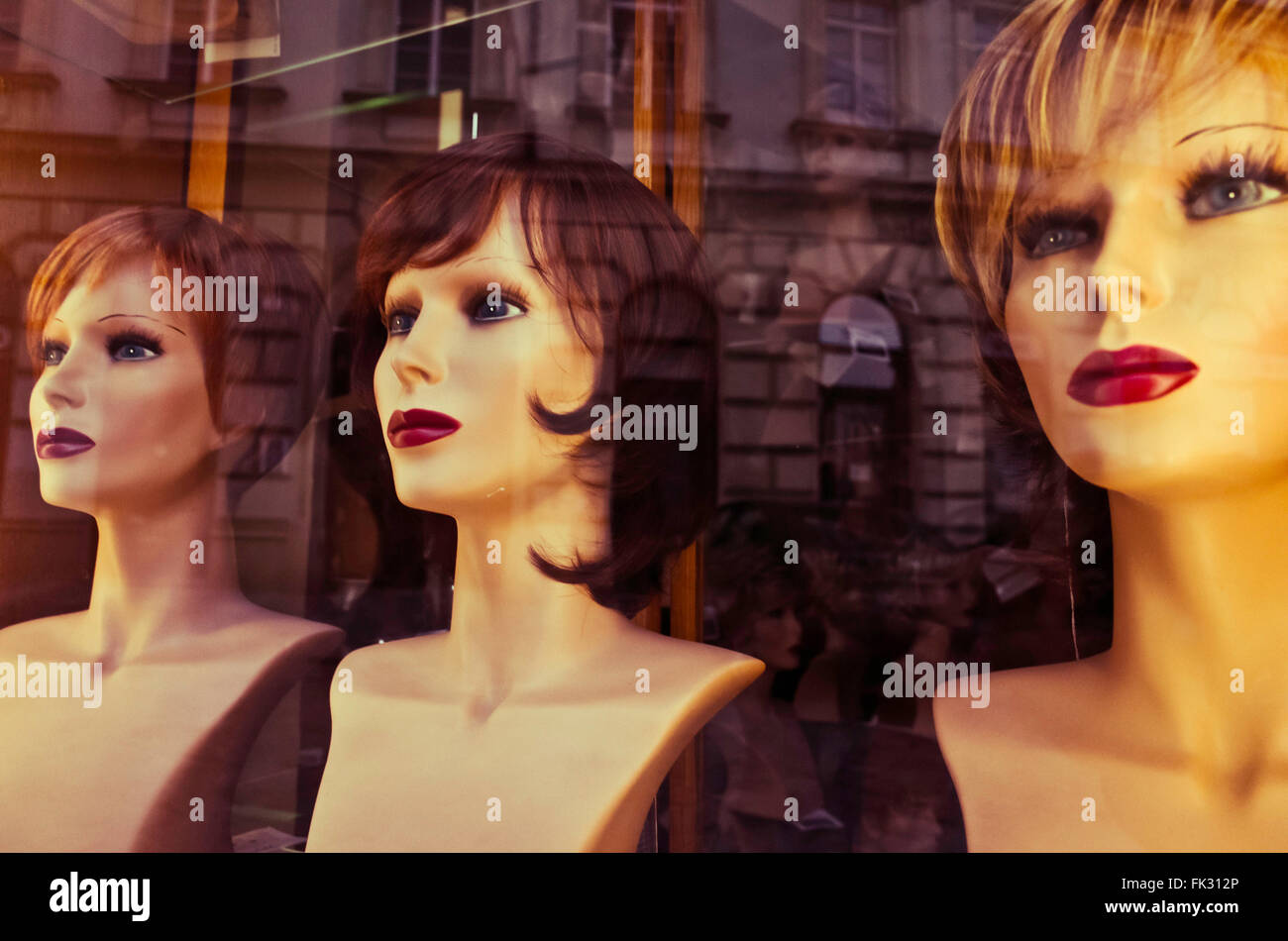 Maniquíes cabezas en una vitrina de una tienda Foto de stock