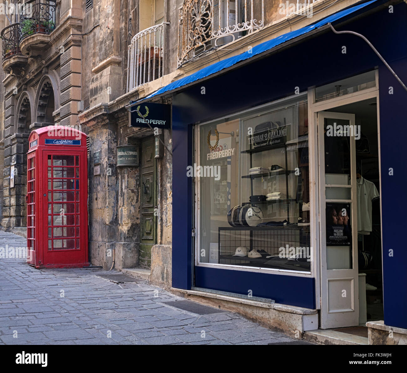Signos de Gran Bretaña: un cuadro teléfono rojo y Fred Perry tienda de ropa  en Merchant Street, Valletta, Malta Fotografía de stock - Alamy