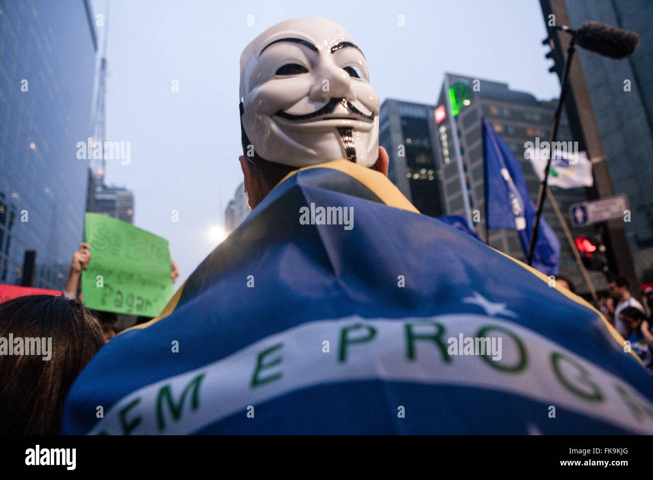 Manifestación con máscaras anónimo y la bandera de Brasil durante el brote Foto de stock