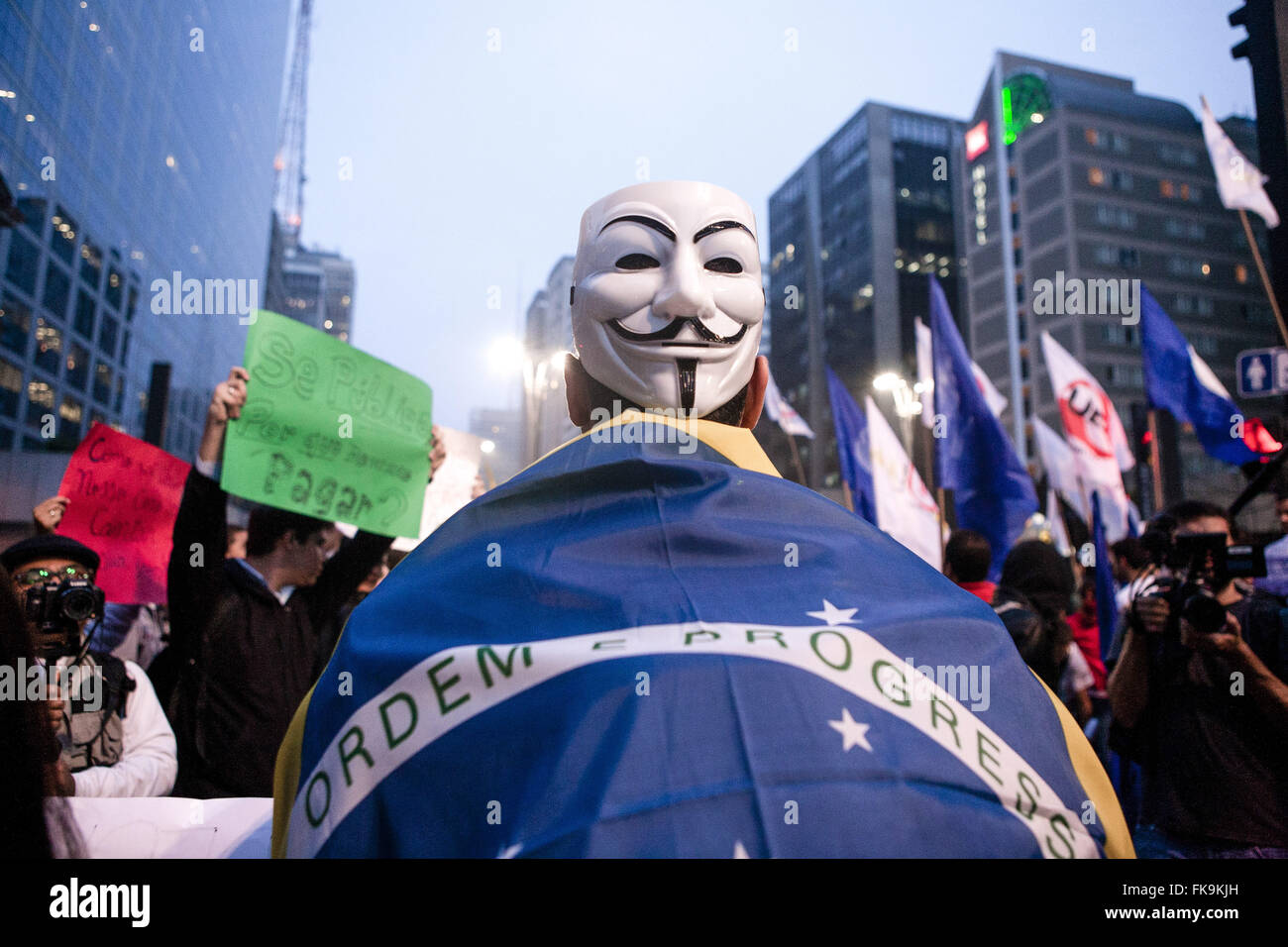 Manifestación con máscaras anónimo y la bandera de Brasil durante el brote Foto de stock