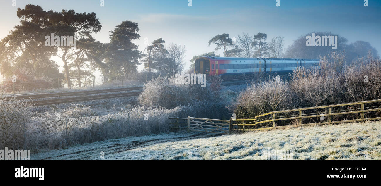 El tren de Exeter a London Waterloo pasando sobre una helada mañana en Milborne Wick, Somerset, Inglaterra Foto de stock