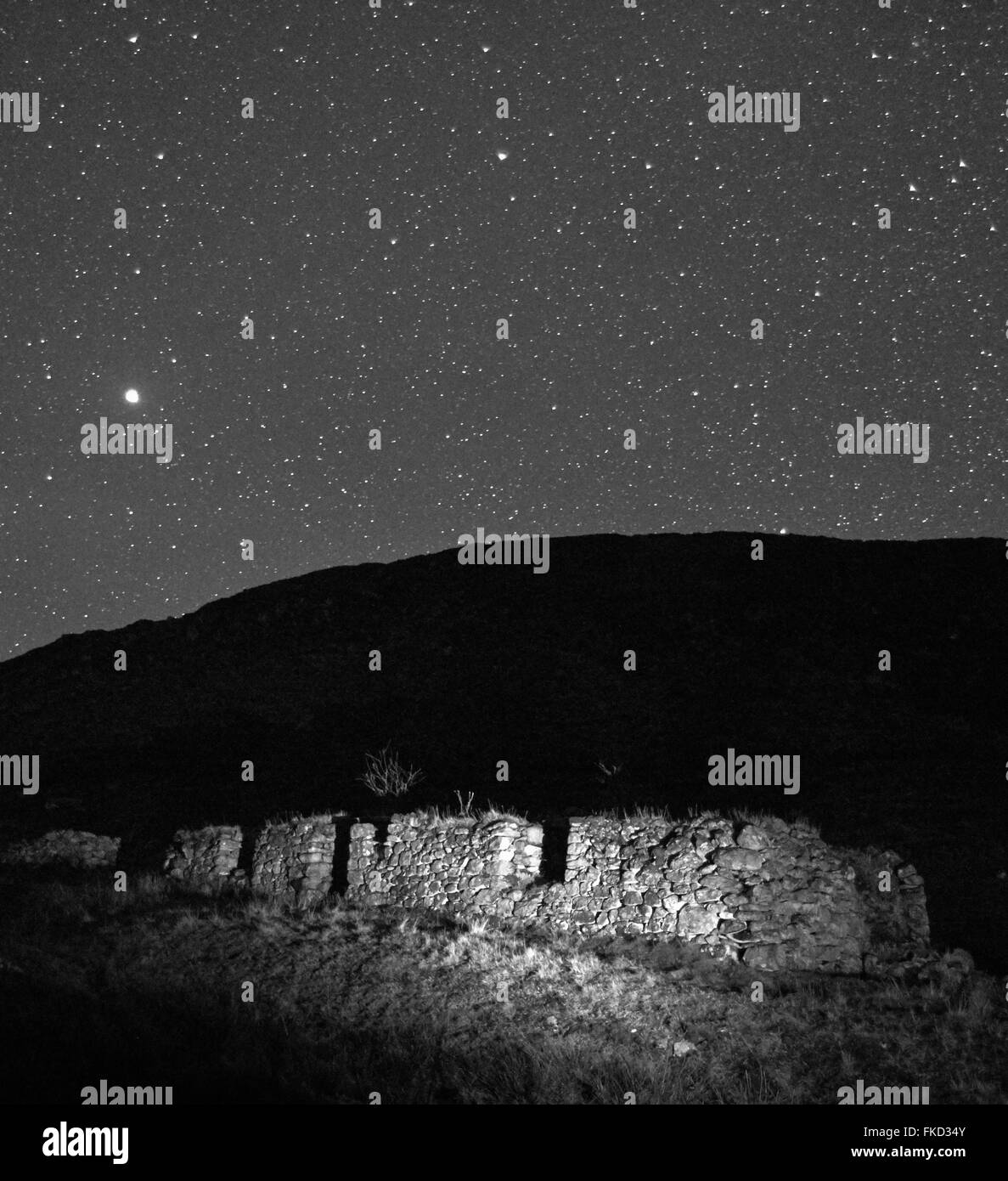 En blanco y negro de filmación nocturna blackhouse abandonados en la isla de Lewis con un cielo estrellado. Foto de stock