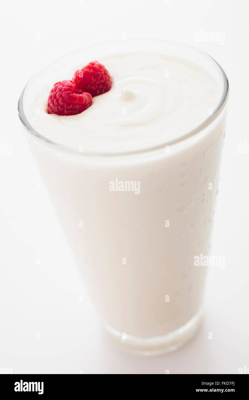 El yogur con frambuesas en vaso Foto de stock